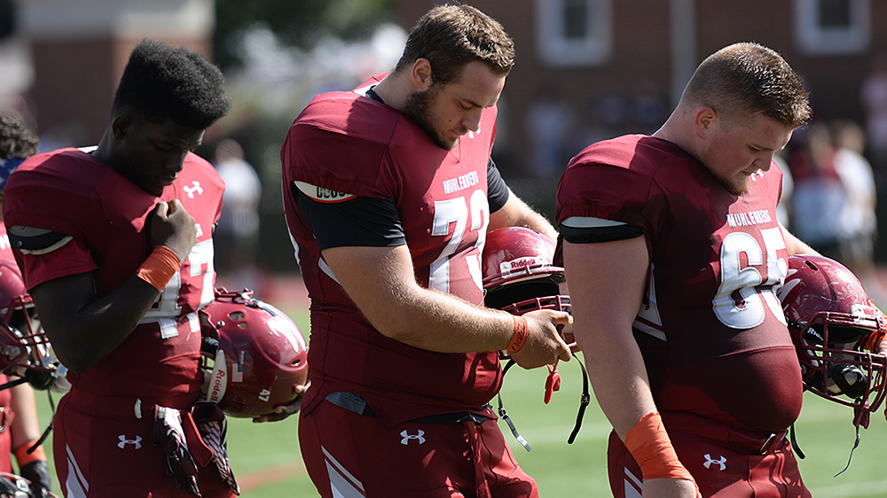 Muhlenberg players with bowed heads